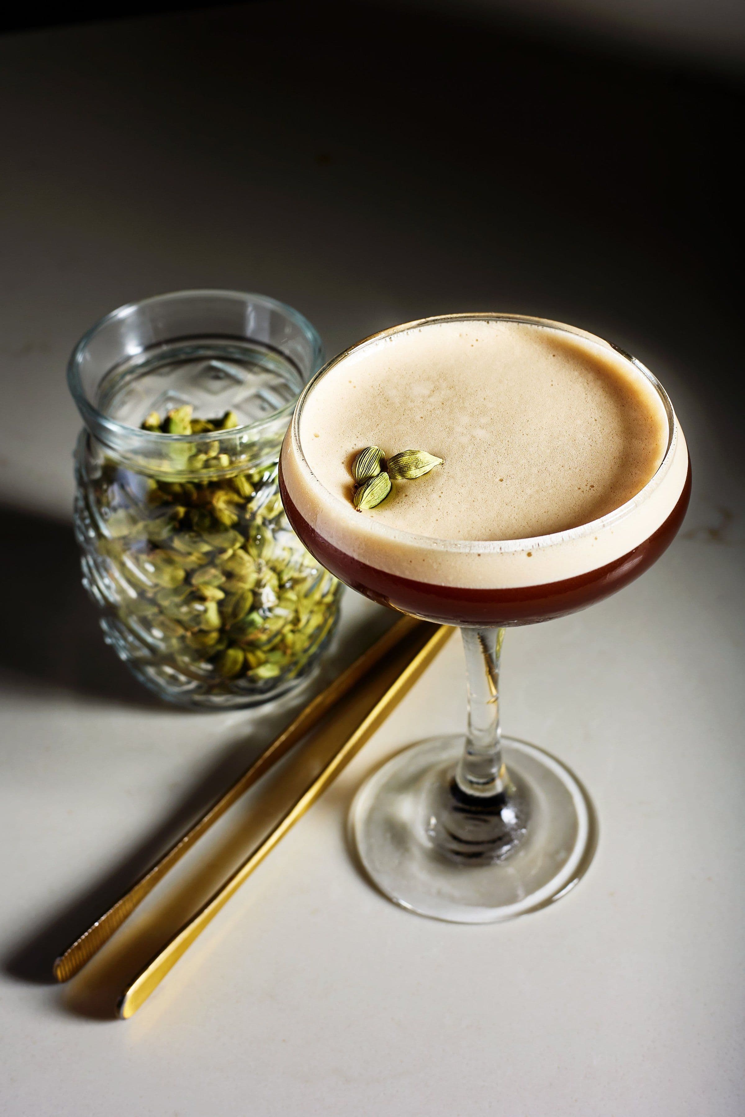 Espresso martini with a jar of cardamom pods
