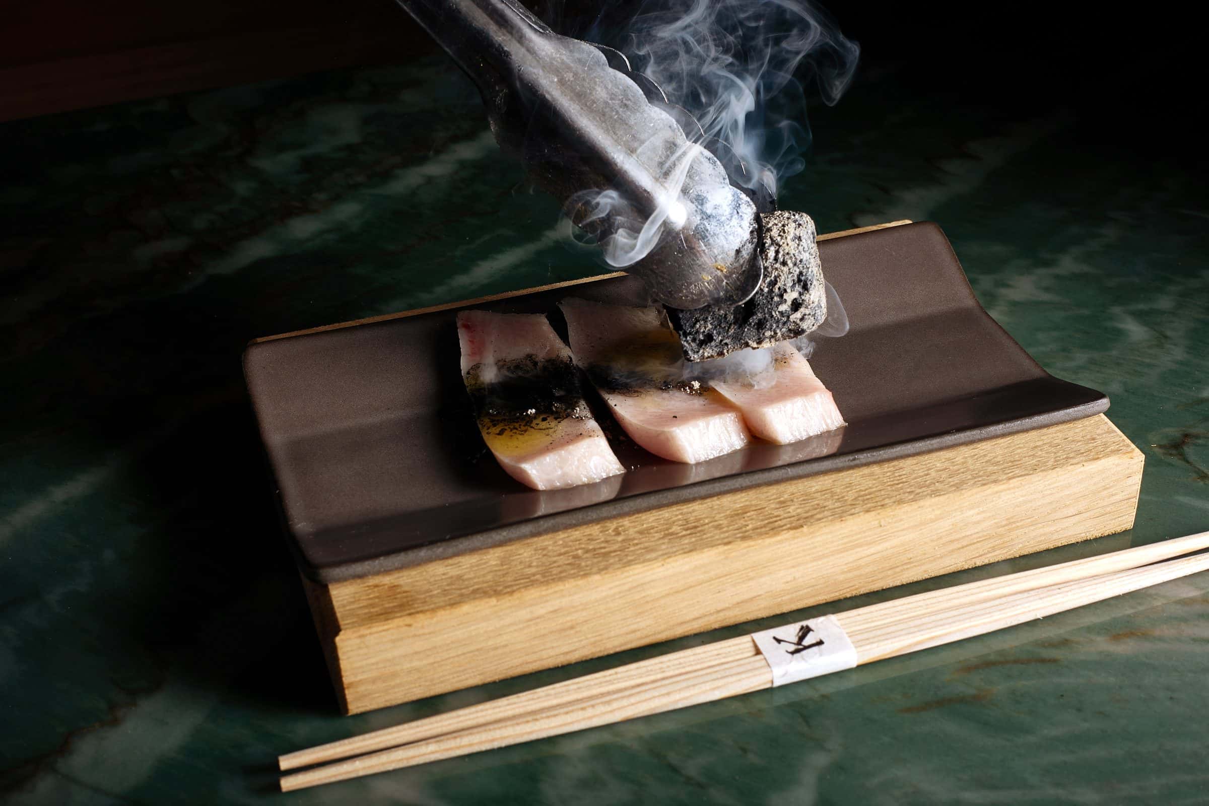 Nigiri set on a smoking cedar box at the omakase counter